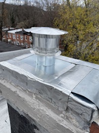 a roof vent with a metal cover on top of it